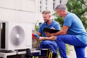 Zwei Techniker arbeiten an Wärmepumpe im Freien